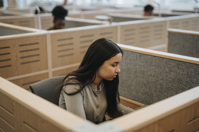 Teenage girl studying in library at university