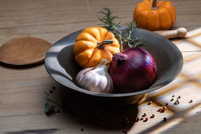 High angle view of pumpkins garlic and onion on table