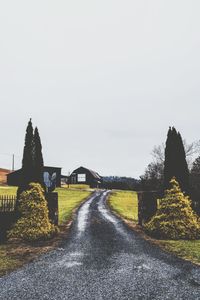 Street amidst plants and trees against sky