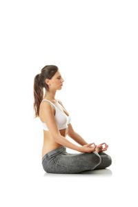 Young woman sitting against white background