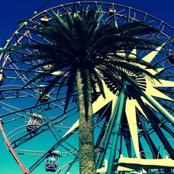 Low angle view of ferris wheel against blue sky