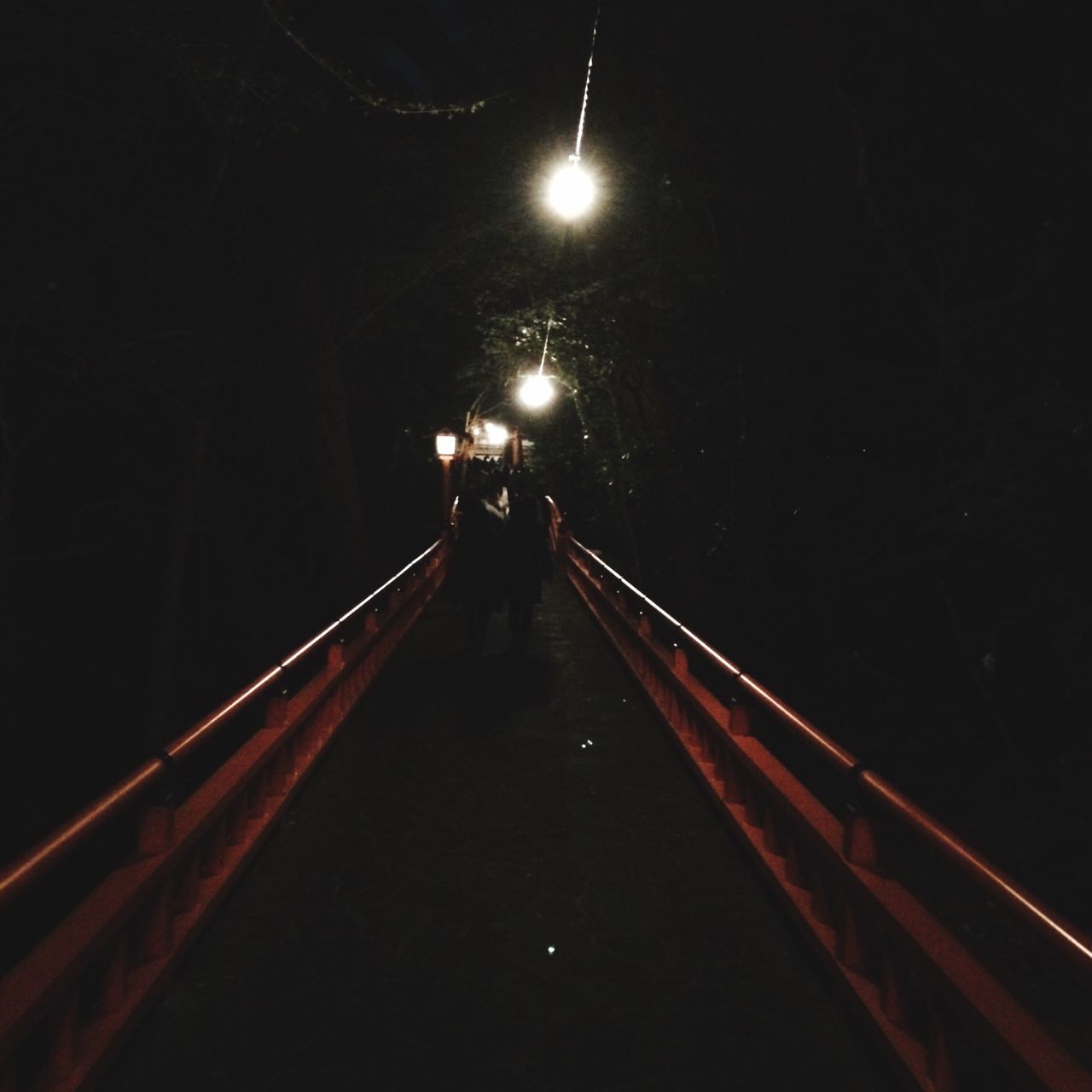 night, illuminated, the way forward, connection, transportation, bridge - man made structure, walking, street light, railing, lighting equipment, diminishing perspective, built structure, vanishing point, rear view, men, lifestyles, tunnel, architecture