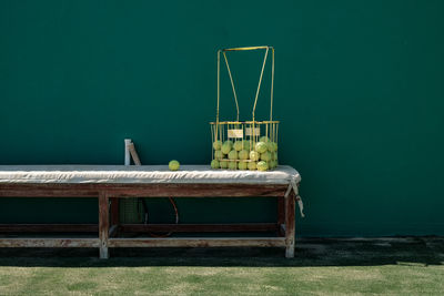 Empty bench on table against wall