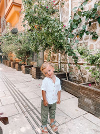 Full length of boy standing against plants