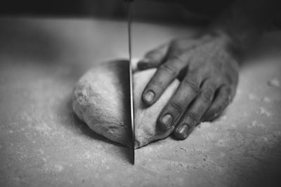 Close-up of man cutting dough 