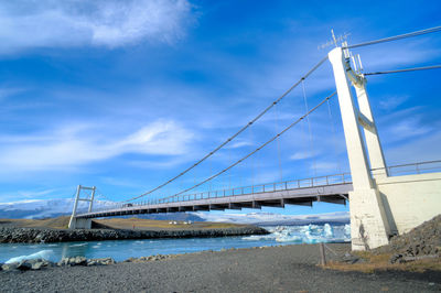 Suspension bridge against cloudy sky