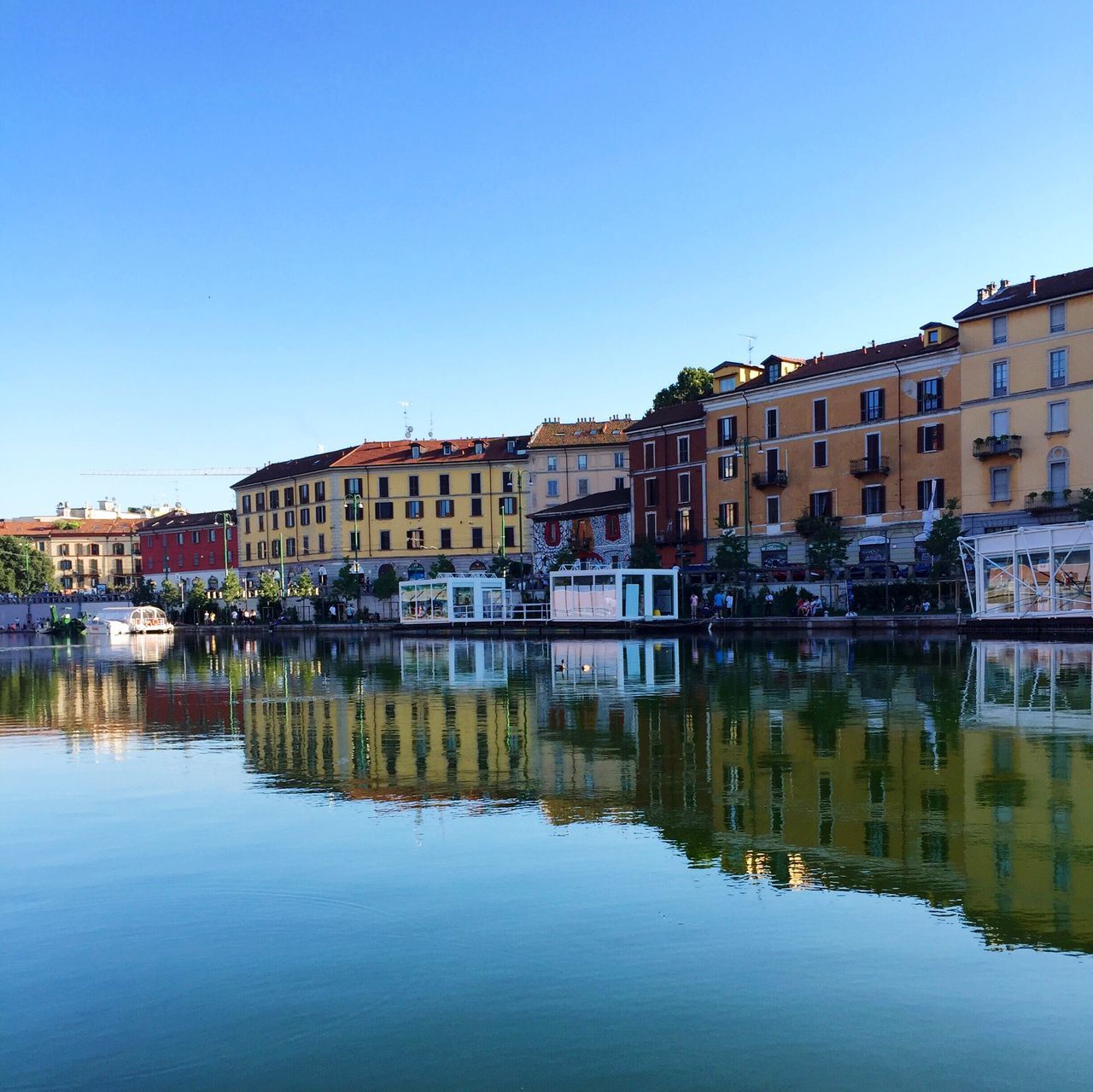 reflection, water, built structure, building exterior, architecture, waterfront, blue, clear sky, sky, travel destinations, outdoors, standing water, city, day, nature, reflection lake, no people, beauty in nature