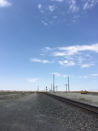 Road amidst field against sky