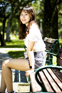 Portrait of smiling woman sitting on bench