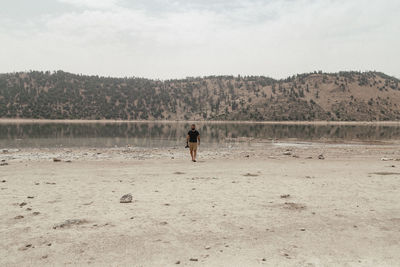 Man on shore against sky