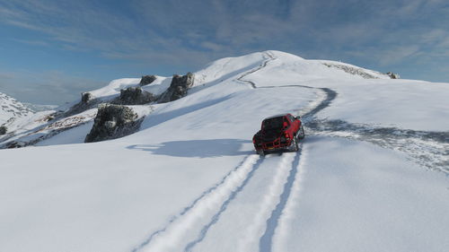 Person on snowcapped mountain against sky