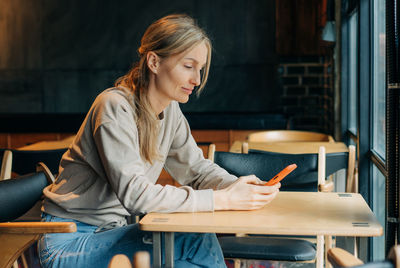 A modern woman uses a mobile phone for online chatting.