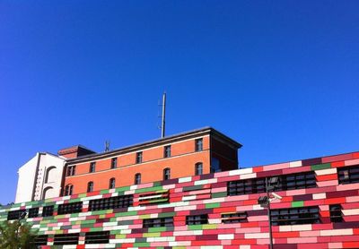 Low angle view of buildings against clear blue sky