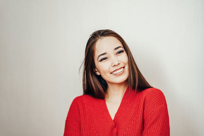 Portrait of a smiling young woman against white background