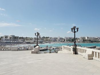 Scenic view of street by sea against sky