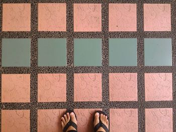 Low section of man standing on tiled floor