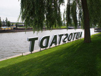 Information sign by river in park