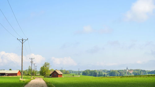 Dirt road at a field with a power line at the swedish countryside 