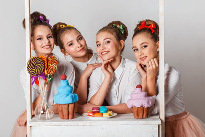 Portrait of happy friends sitting on table