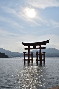 Lifeguard hut on sea against cloudy sky