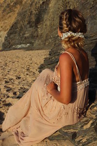 Rear view of woman sitting on beach