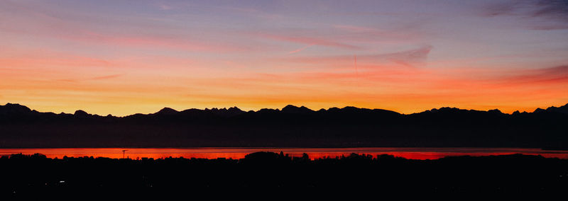 Scenic view of silhouette landscape against orange sky