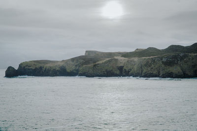 Scenic view of sea and mountains against sky