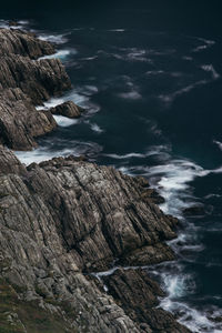 Scenic view of sea by cliff against sky