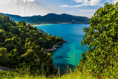 Scenic view of sea and mountains against sky