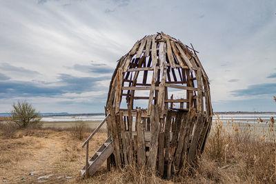 Abandoned structure on field against sky