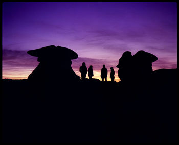 Silhouette people standing against sky during sunset