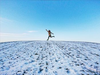 Man standing on snow covered land against sky