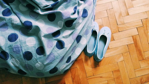 High angle view of fabric and shoes on hardwood floor