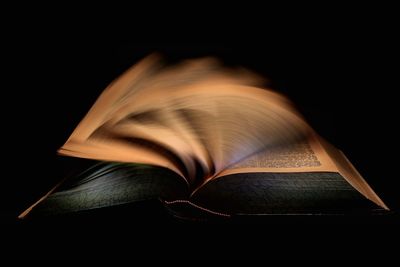 Close-up of book against black background