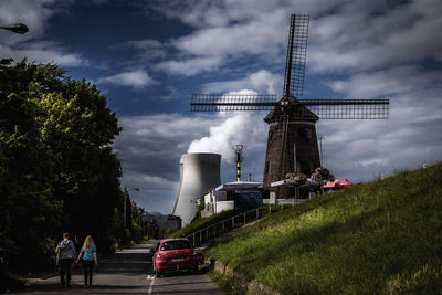 Traditional windmill on field against sky