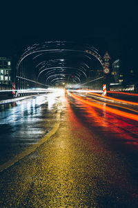 Light trails on road against clear sky at night