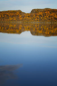 Scenic view of lake by mountain against sky