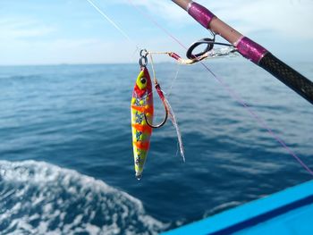 Low angle view of rope hanging in sea against sky