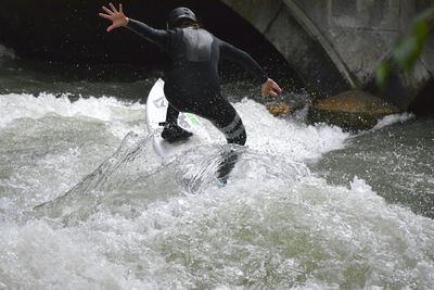 Rear view of person surfboarding