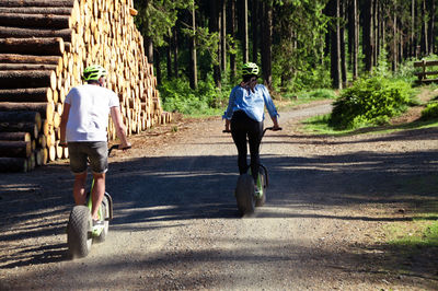 Rear view of people riding motorcycle on road