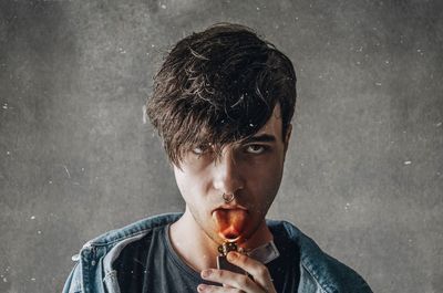 Portrait of young man smoking cigarette