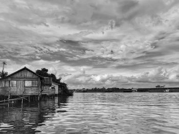 Houses by sea against sky