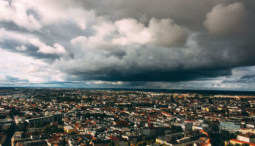 Aerial view of cityscape against storm clouds