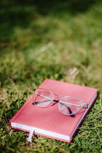 High angle view of eyeglasses on sunglasses on field