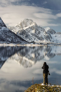 Scenic view of lake by snowcapped mountains against sky