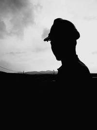 Silhouette of people against cloudy sky