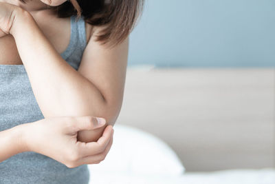 Midsection of woman holding hands at beach