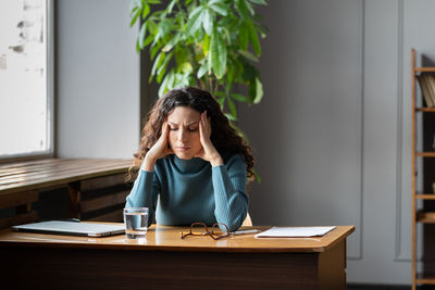 Stressed female employee feeling nervous at work, businesswoman suffering from high blood pressure