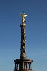 Low angle view of statue of liberty against blue sky