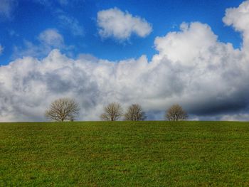 Scenic view of grassy field against cloudy sky